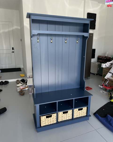 Navy hall tree with bench, hooks and storage cubbies assembled in an entryway