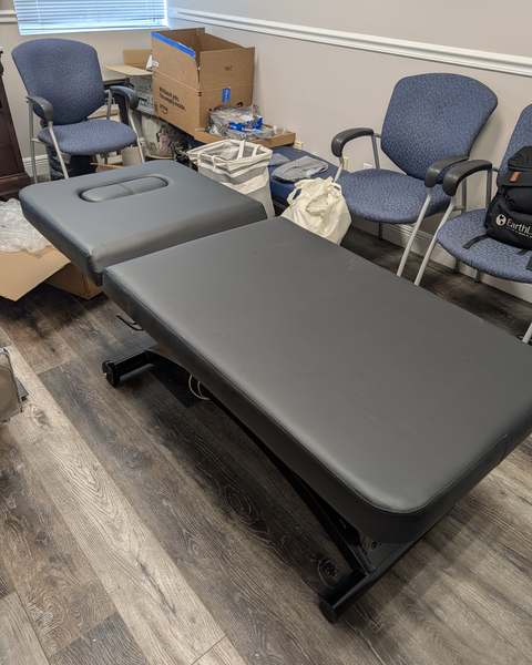 Height-adjustable massage table assembled in a wellness studio