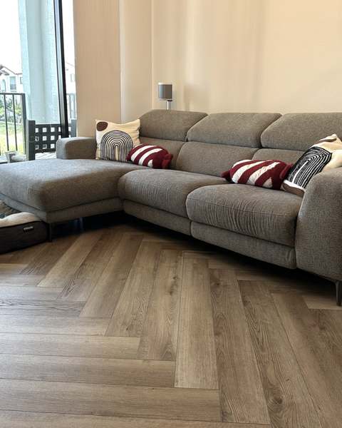 Gray reclining sectional sofa assembled in a living room with wood-look floors