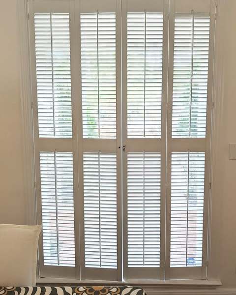 Tall white plantation shutters adjusted and repaired so the louvers close evenly